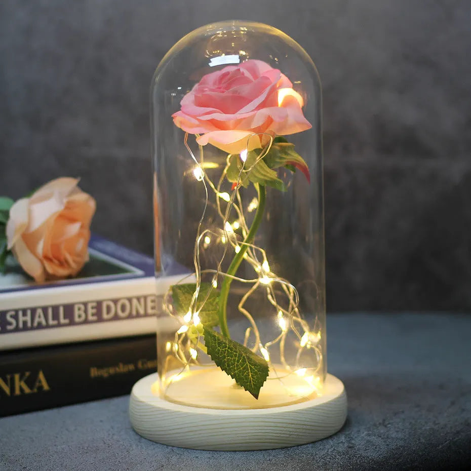 LED rose ornament with silk flowers under glass shade, showing colour options on a wooden base.