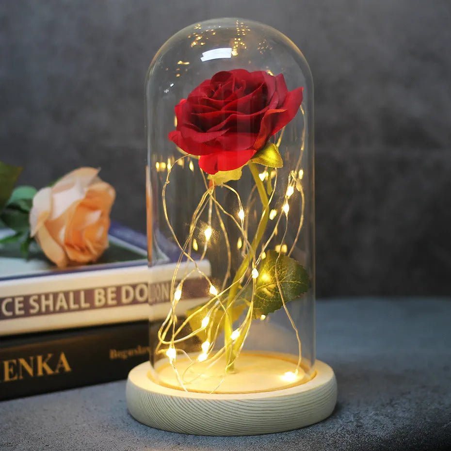 LED rose ornament with silk flowers under glass shade, showing colour options on a wooden base.