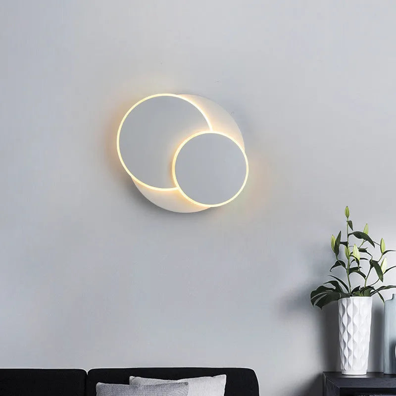 Modern round acrylic wall lamp in black or white, shown in 14cm, 18cm and 22cm diameter sizes.