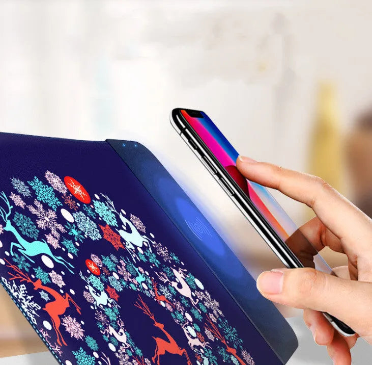 Black wireless charging mouse pad with cartoon design, RGB edge lighting, and non-slip rubber base.