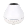 White circular Bluetooth humidifier and aroma diffuser with single mist outlet on a table
