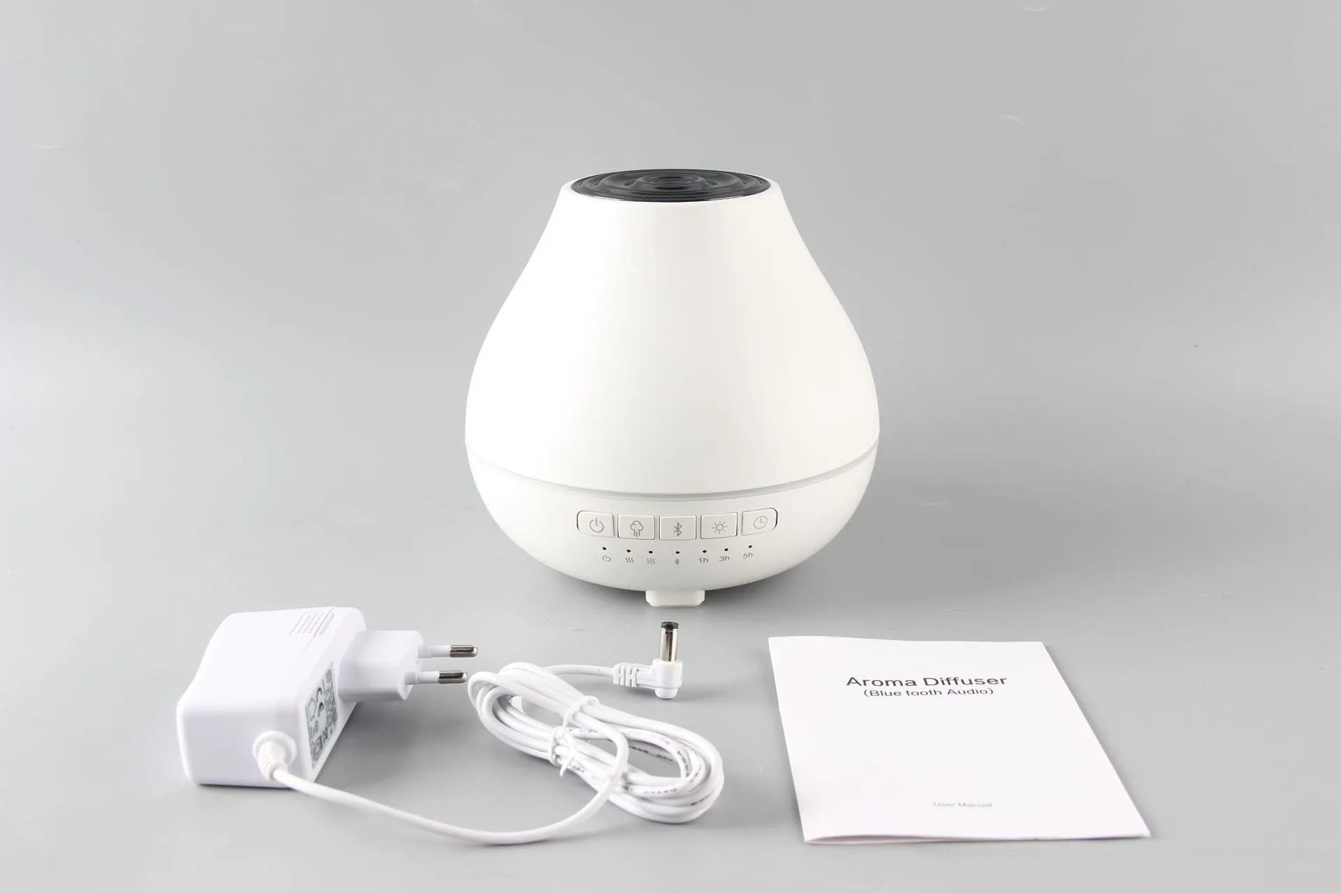 White circular Bluetooth humidifier and aroma diffuser with single mist outlet on a table