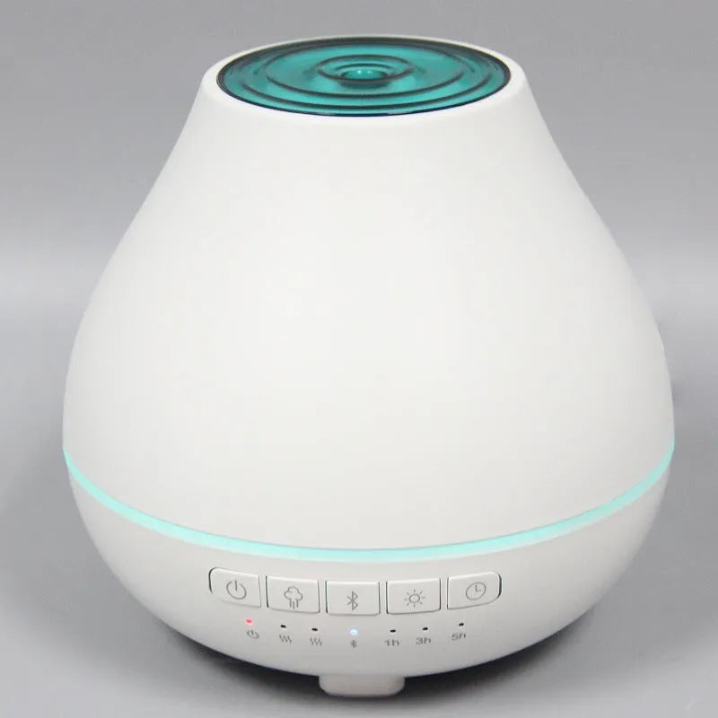 White circular Bluetooth humidifier and aroma diffuser with single mist outlet on a table