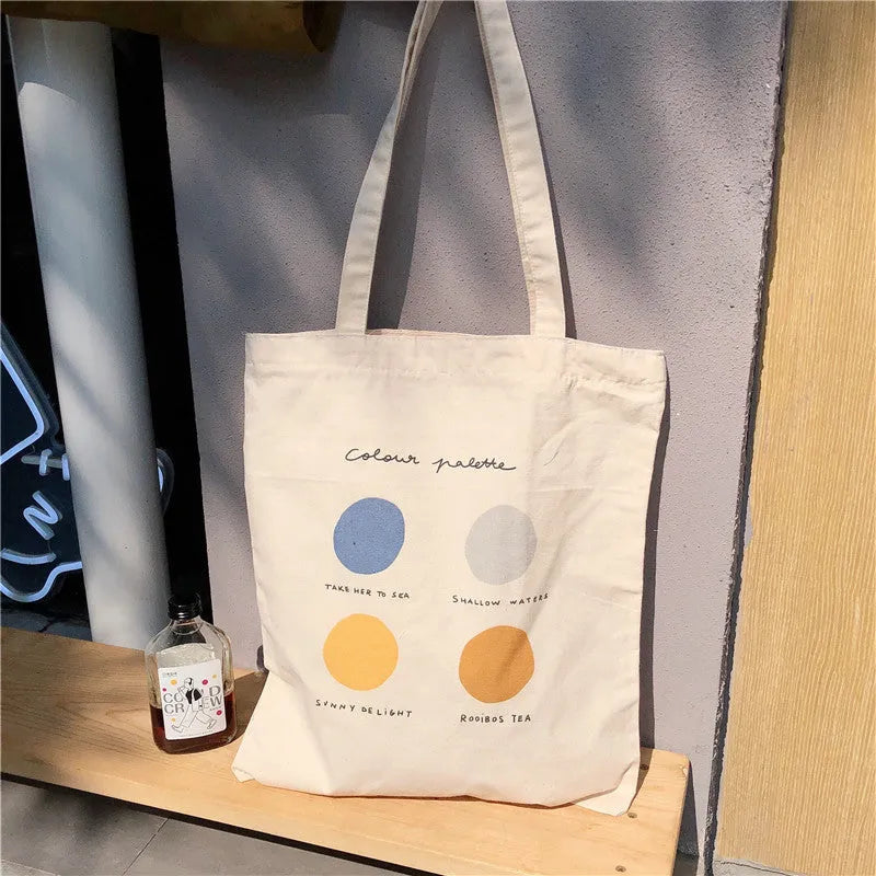 Women's orange geometric print canvas tote bag with zipper closure and shoulder straps.