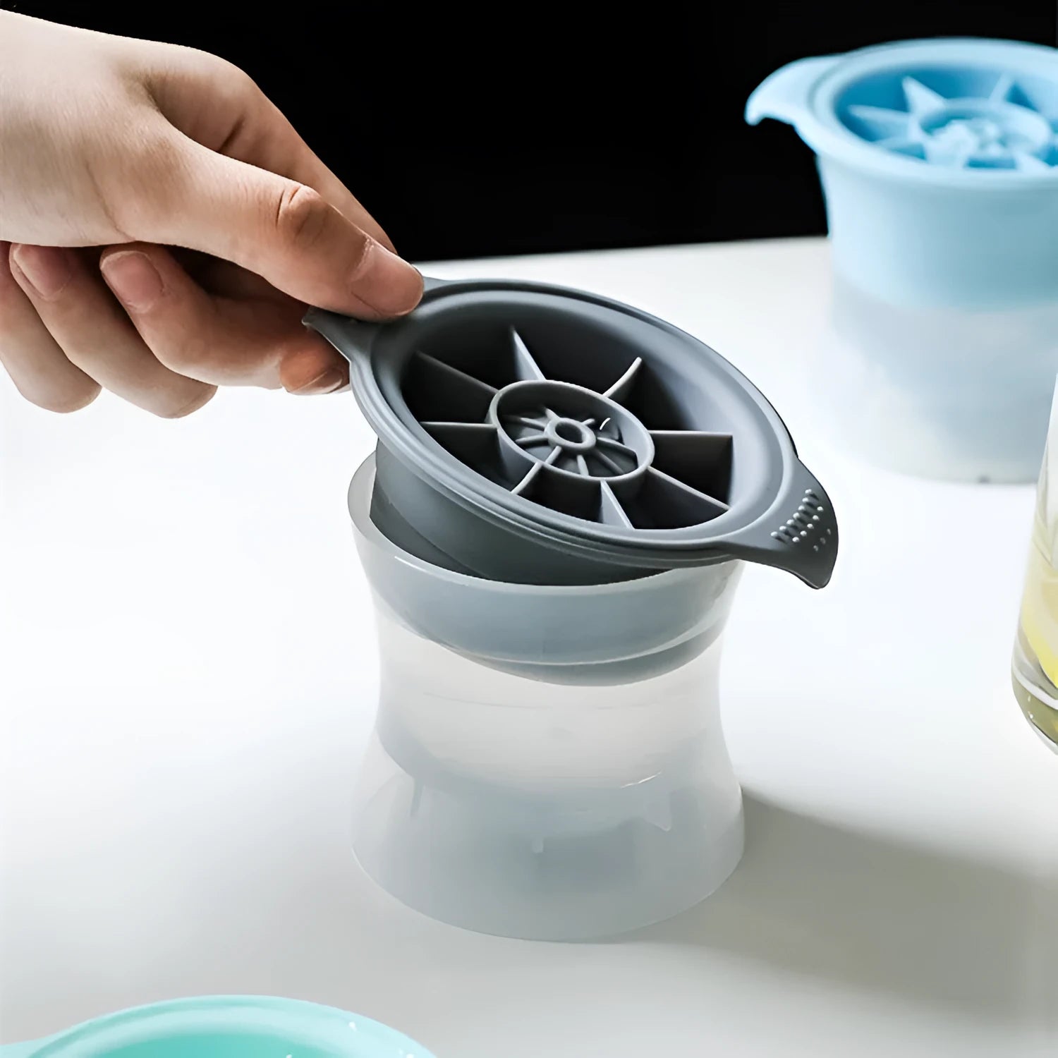 Silicone ice tray showing hockey puck moulds and spherical ice moulds in light blue colour