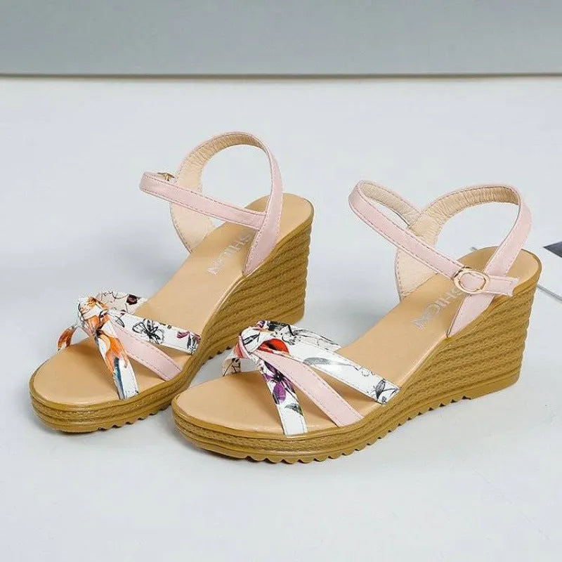 Women's pink wedge sandals with a fish mouth open toe and a buckle strap on a non-slip sole.