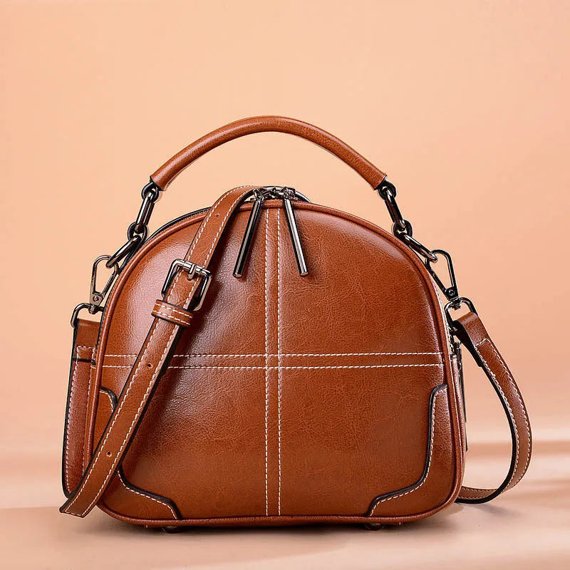Simple round leather women's handbag with soft double handles and a zipper opening