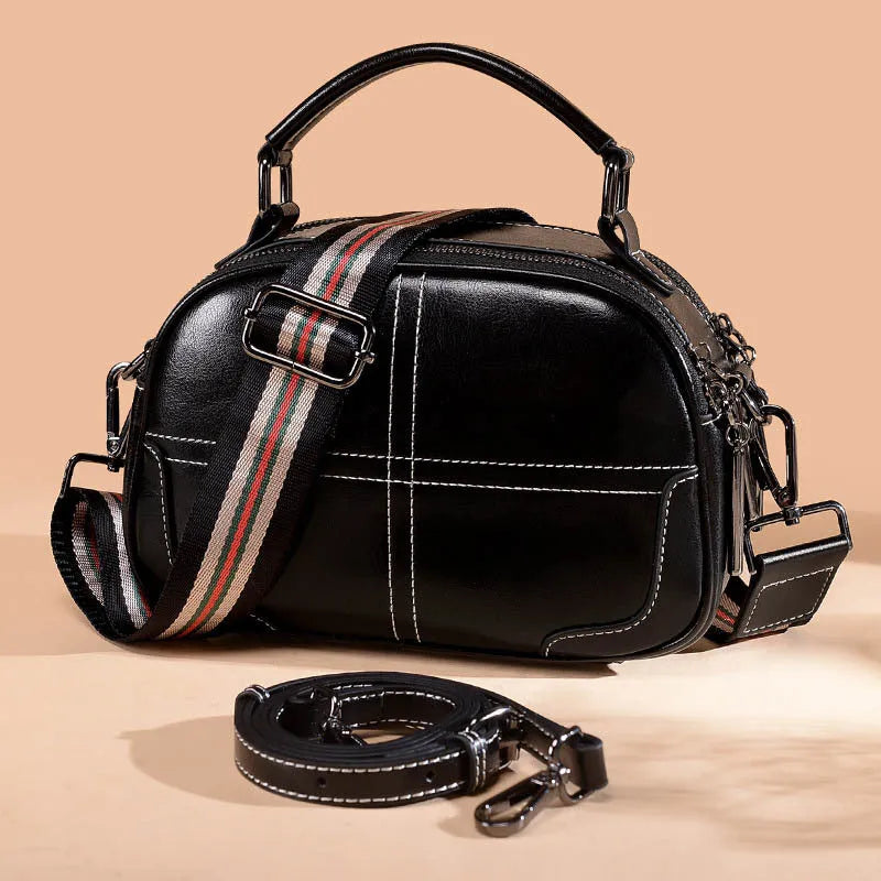 Simple round leather women's handbag with soft double handles and a zipper opening