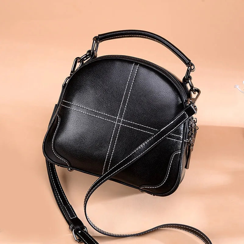 Simple round leather women's handbag with soft double handles and a zipper opening