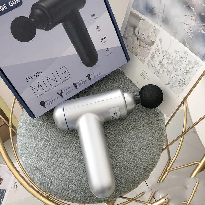 Grey handheld fascia gun muscle massager with USB charging port and adjustable speed controls