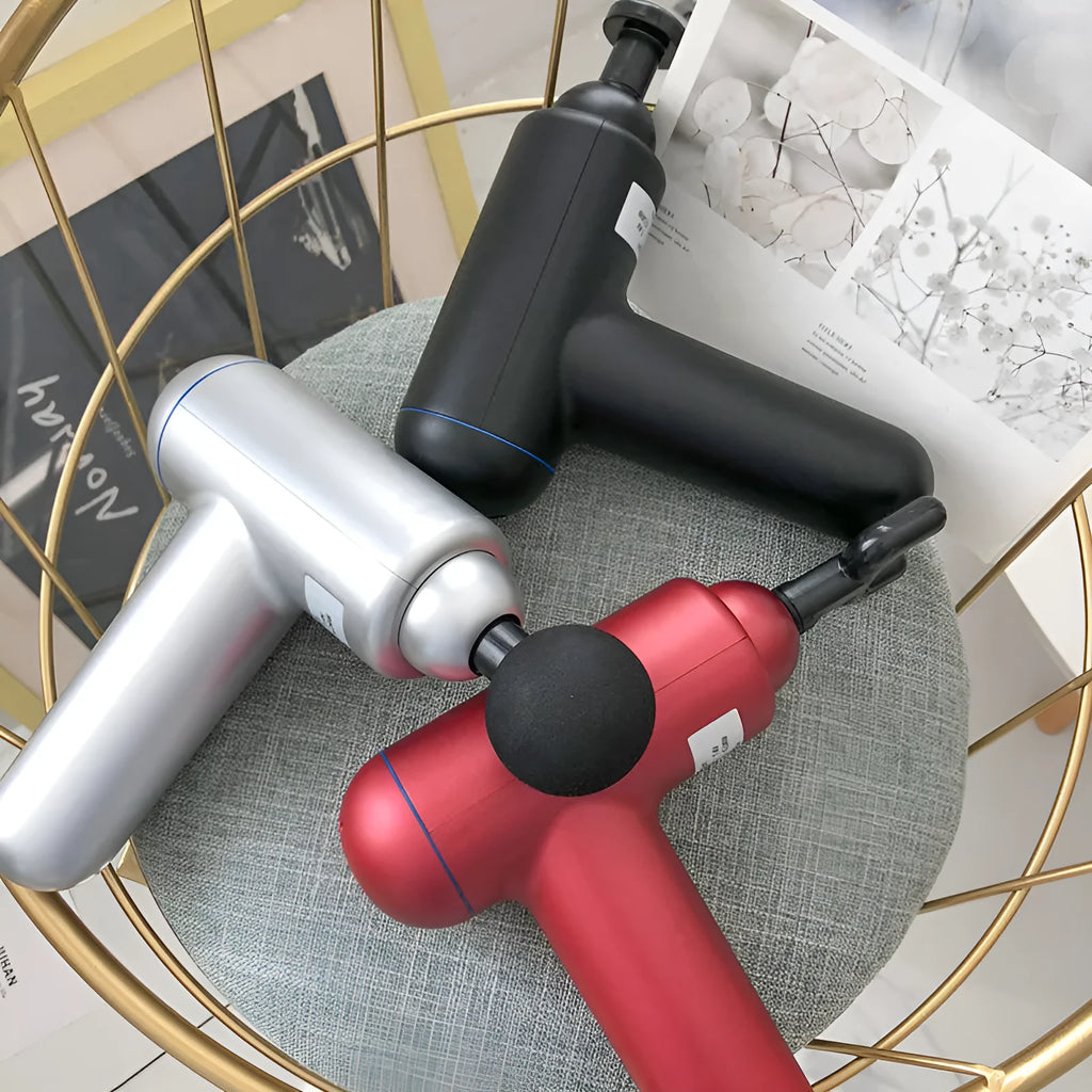 Grey handheld fascia gun muscle massager with USB charging port and adjustable speed controls