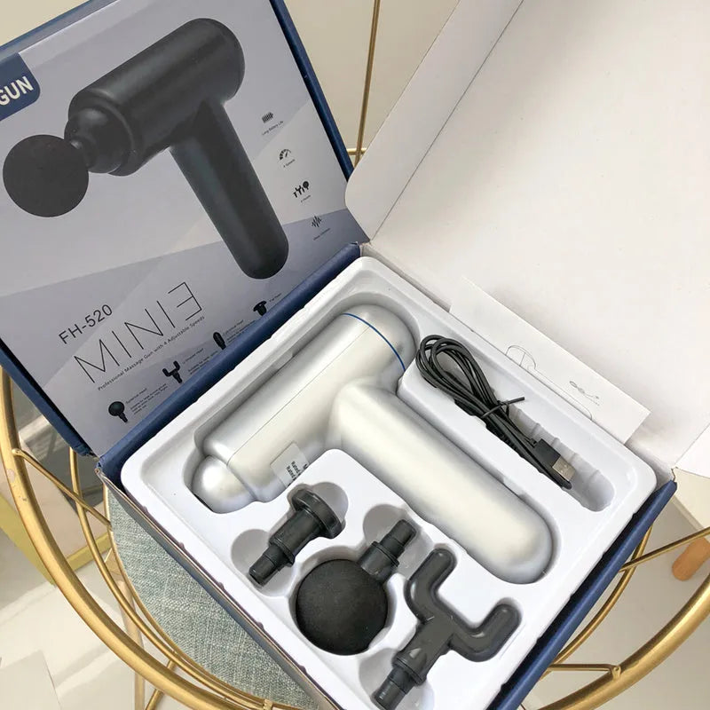 Grey handheld fascia gun muscle massager with USB charging port and adjustable speed controls