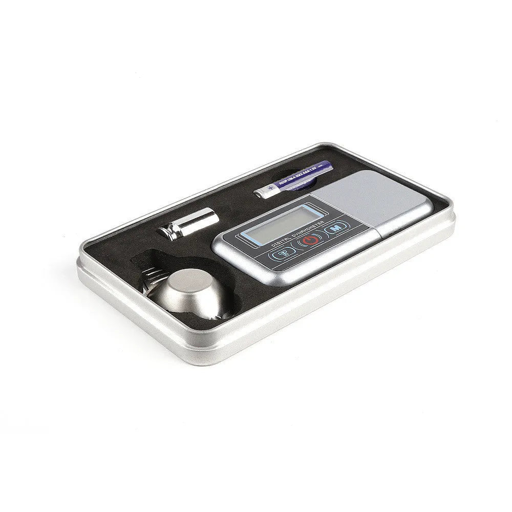 Small digital electronic scale on a table showing 0.005g accuracy.