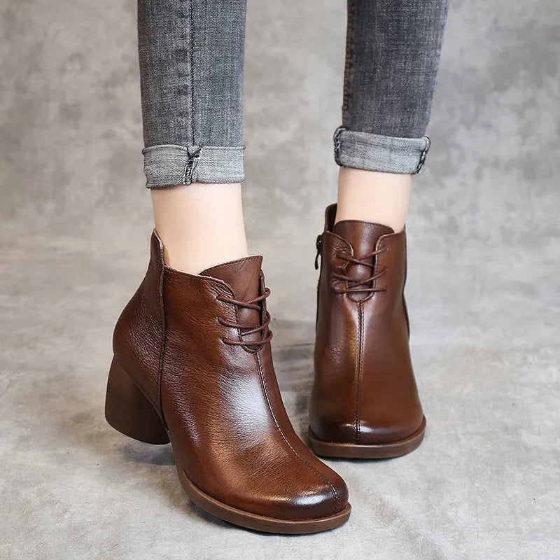Women's black leather Martin boots with a thick, round heel and vintage styling.