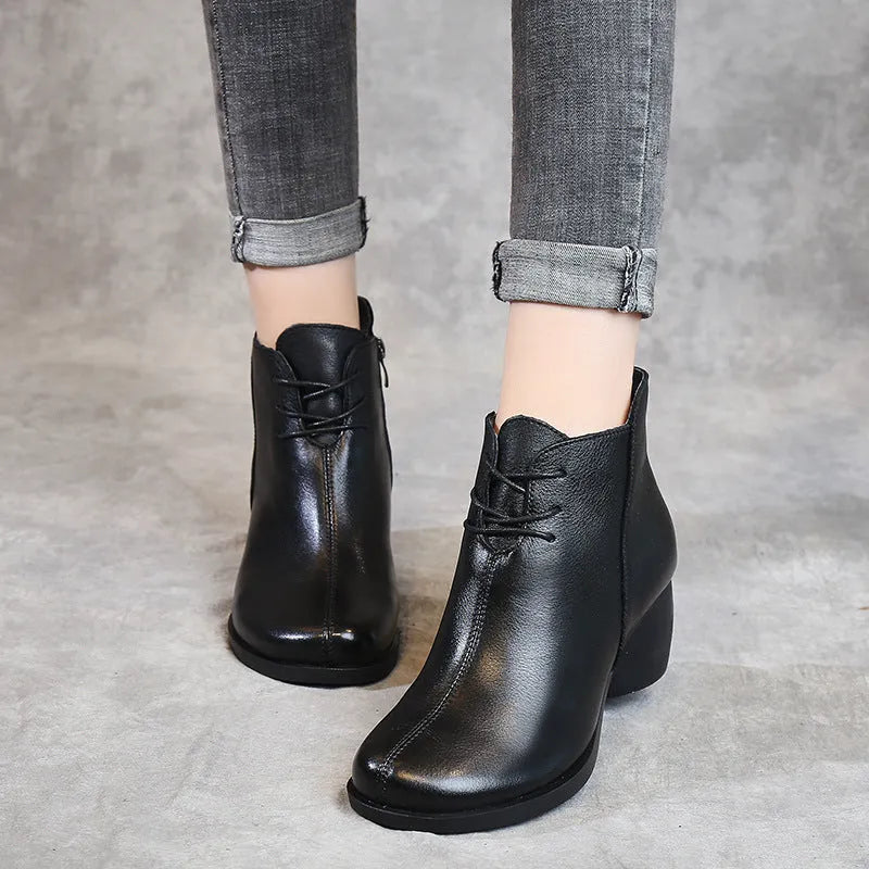 Women's black leather Martin boots with a thick, round heel and vintage styling.