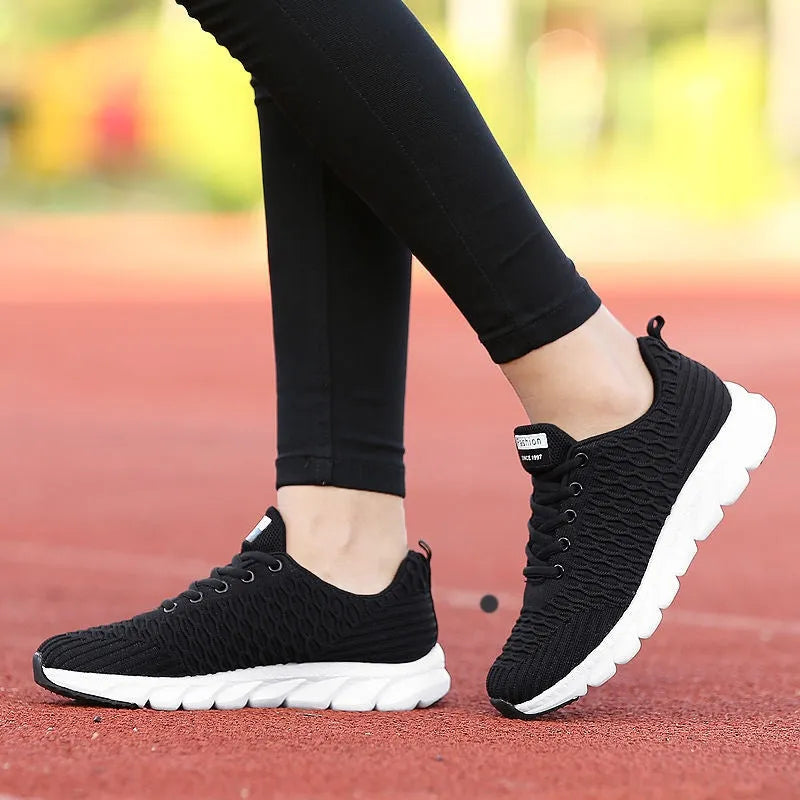 Women's running shoes in black, pink, or white with a detailed fly weaving upper and durable outsole.