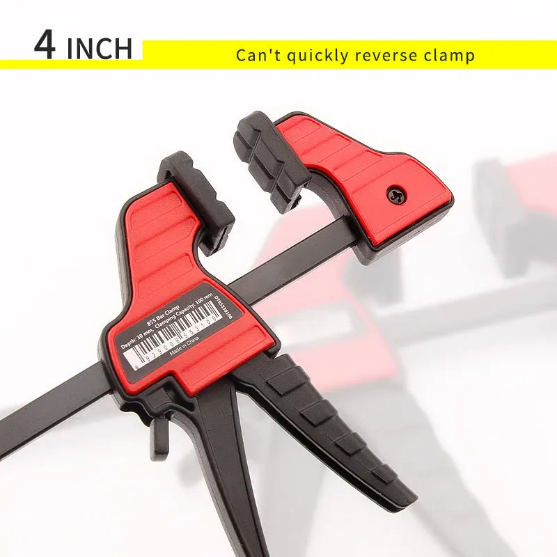 Black plastic woodworking clamp with quick-adjust key and soft rubber protective jaws.