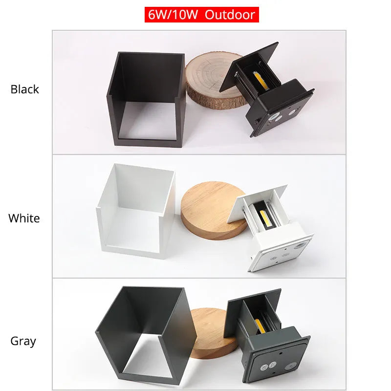 Compact black aluminium cube LED wall lamp mounted on a white wall.