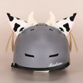 Plush fabric ski helmet decoration with cartoon design on a black ski helmet.