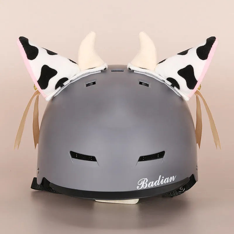 Plush fabric ski helmet decoration with cartoon design on a black ski helmet.