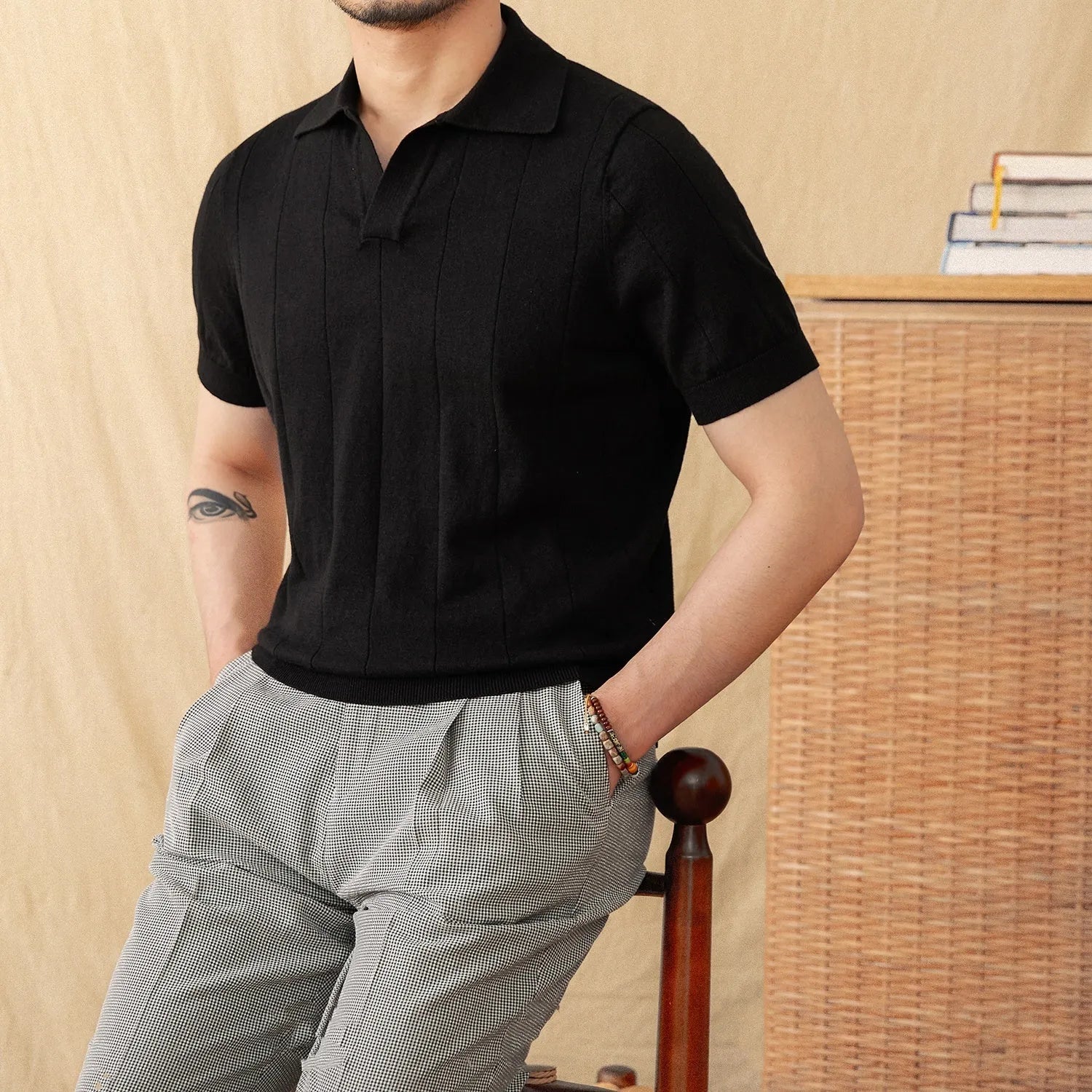 Man modelling a purple short sleeve polo shirt with a sunken stripe knit pattern and a seagull collar.