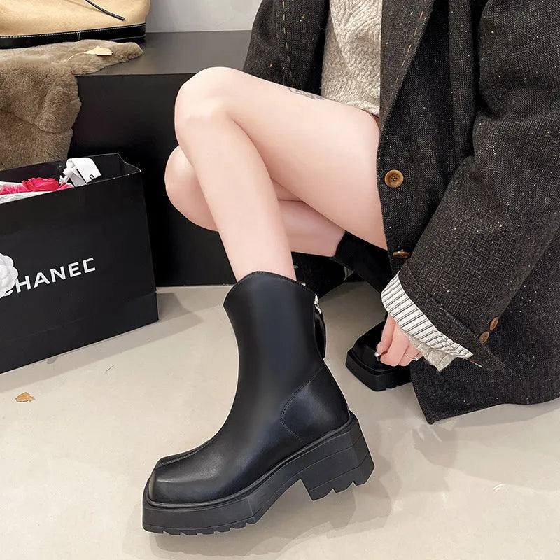 Women's black platform Martin boots with square toe, chunky heel, and back zipper on a white background.