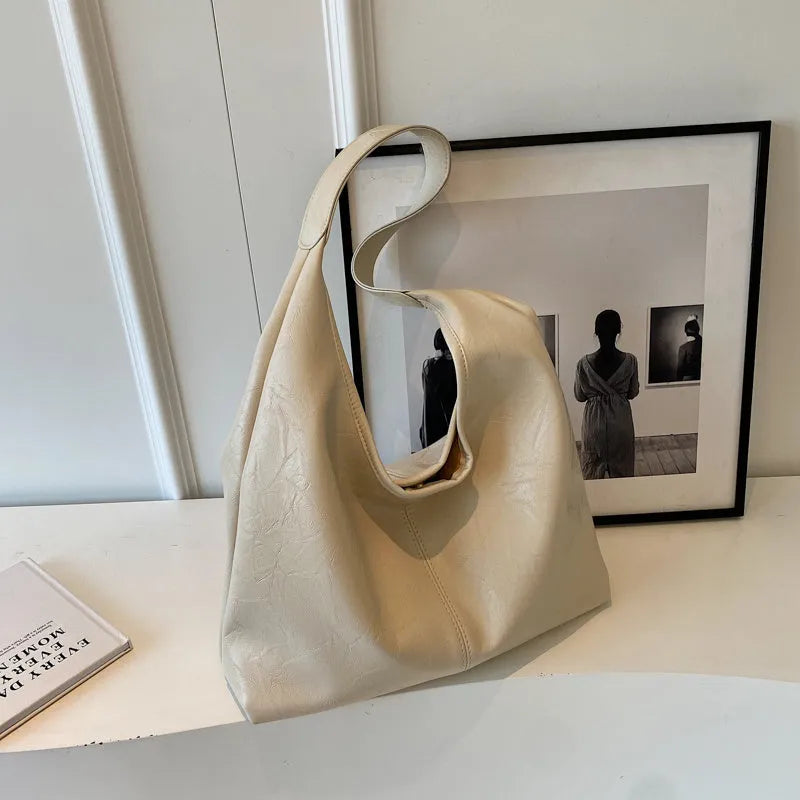 Soft leather shoulder bag in black with sandwich pocket design and shoulder strap