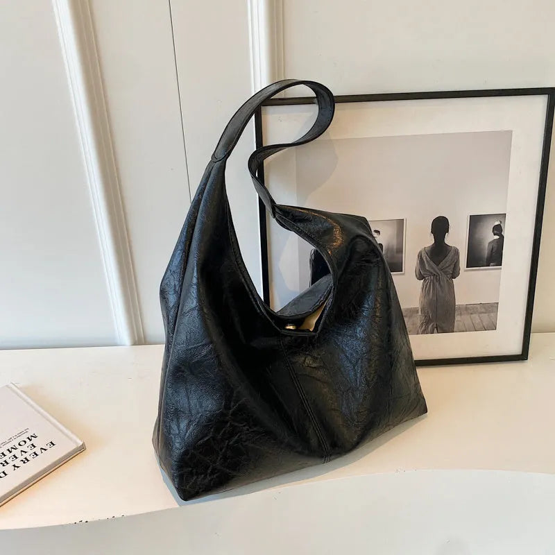 Soft leather shoulder bag in black with sandwich pocket design and shoulder strap