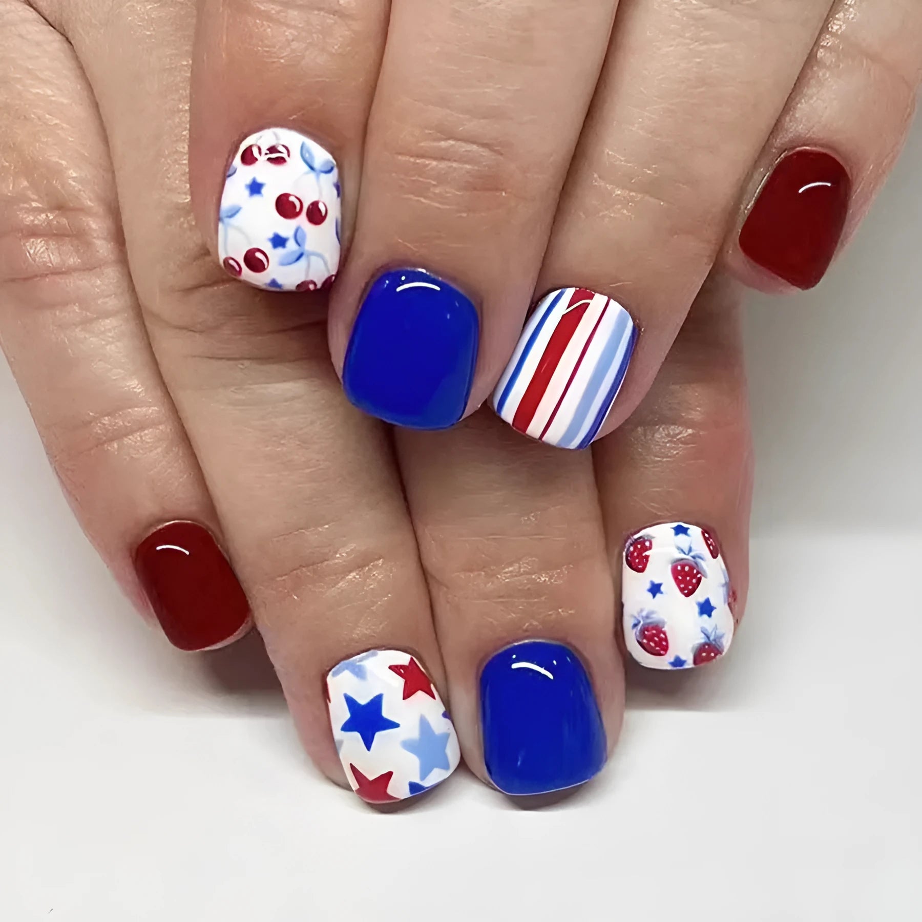 Short glossy nail stickers with red and blue strawberry and cherry pattern, 24 pieces.