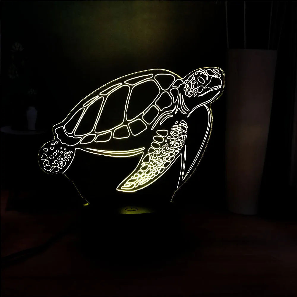 Clear acrylic 3D turtle-shaped LED night light showing multiple colour options on a dark surface.