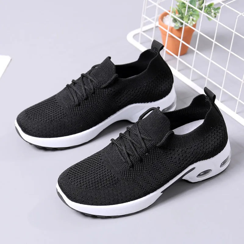 Women's black mesh casual sneaker with round toe and white non-slip PVC sole, shown from the side.