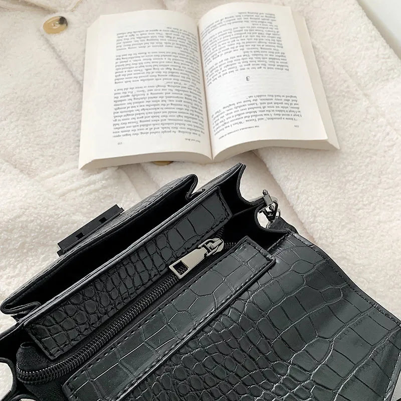 Vintage PU crossbody bag in black, shown with adjustable strap and open to reveal polyester lining.