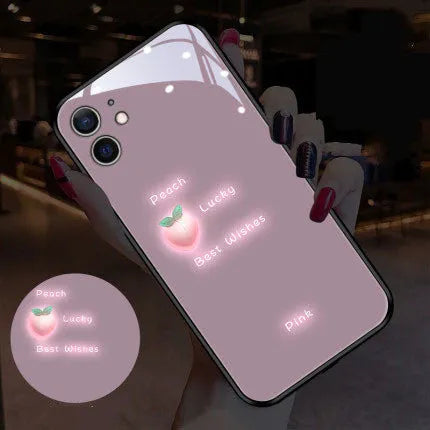 White luminous iPhone case with purple daisy design and voice-activated colour light on a table.