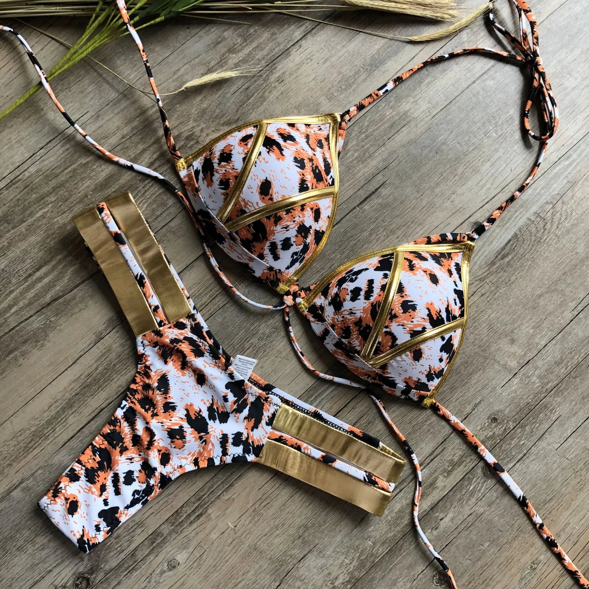 Women's bronzing bikini swimsuit with removable pads and cotton lining on a mannequin.