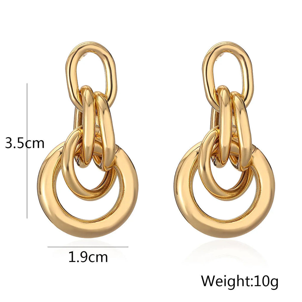 A pair of gold-toned geometric drop earrings with an irregular shape, made from copper.