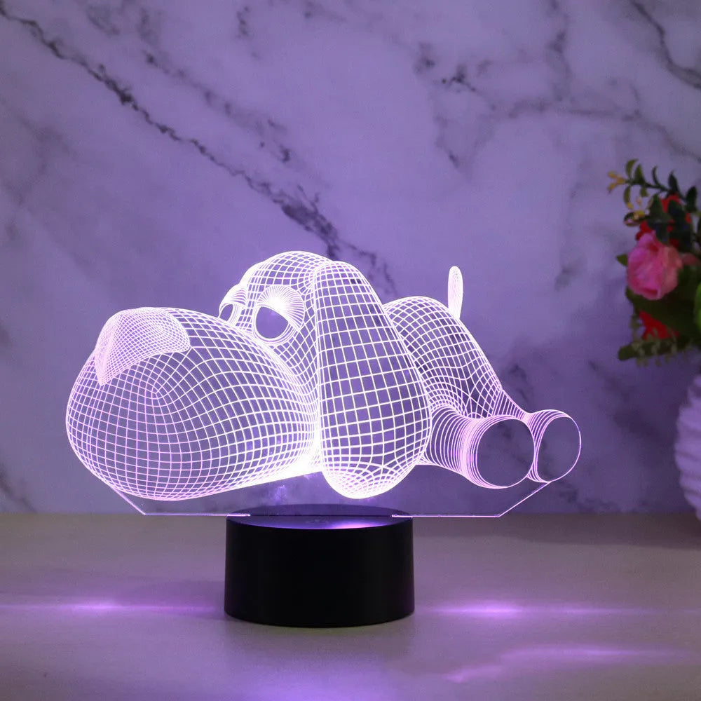 Dog-shaped 3D desktop lamp glowing in multiple colours on a wooden surface.