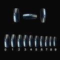 500 clear acrylic false nails in assorted sizes arranged next to application brush and bottle.