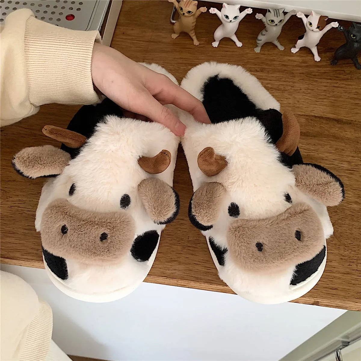 White cow design slippers with plush faux fur upper and textured non-slip sole