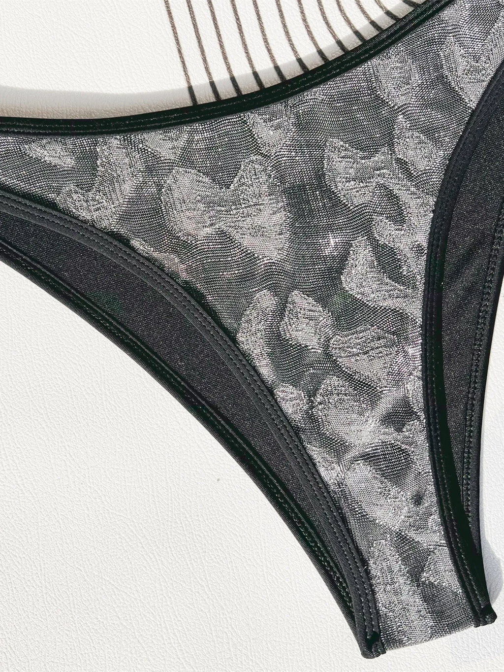 Women's black bikini swimsuit with strap design on a mannequin.