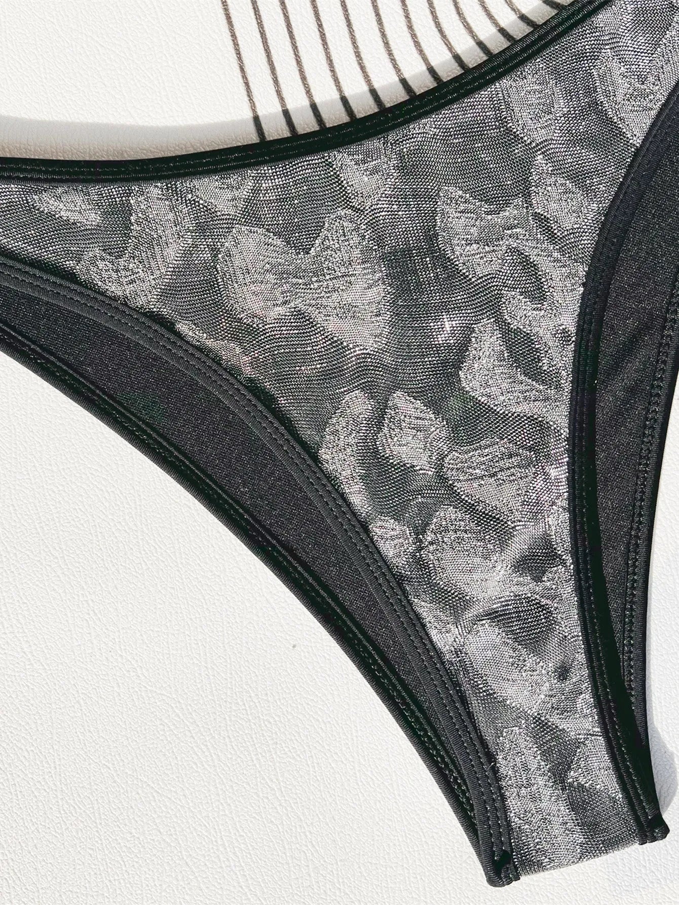 Women's black bikini swimsuit with strap design on a mannequin.