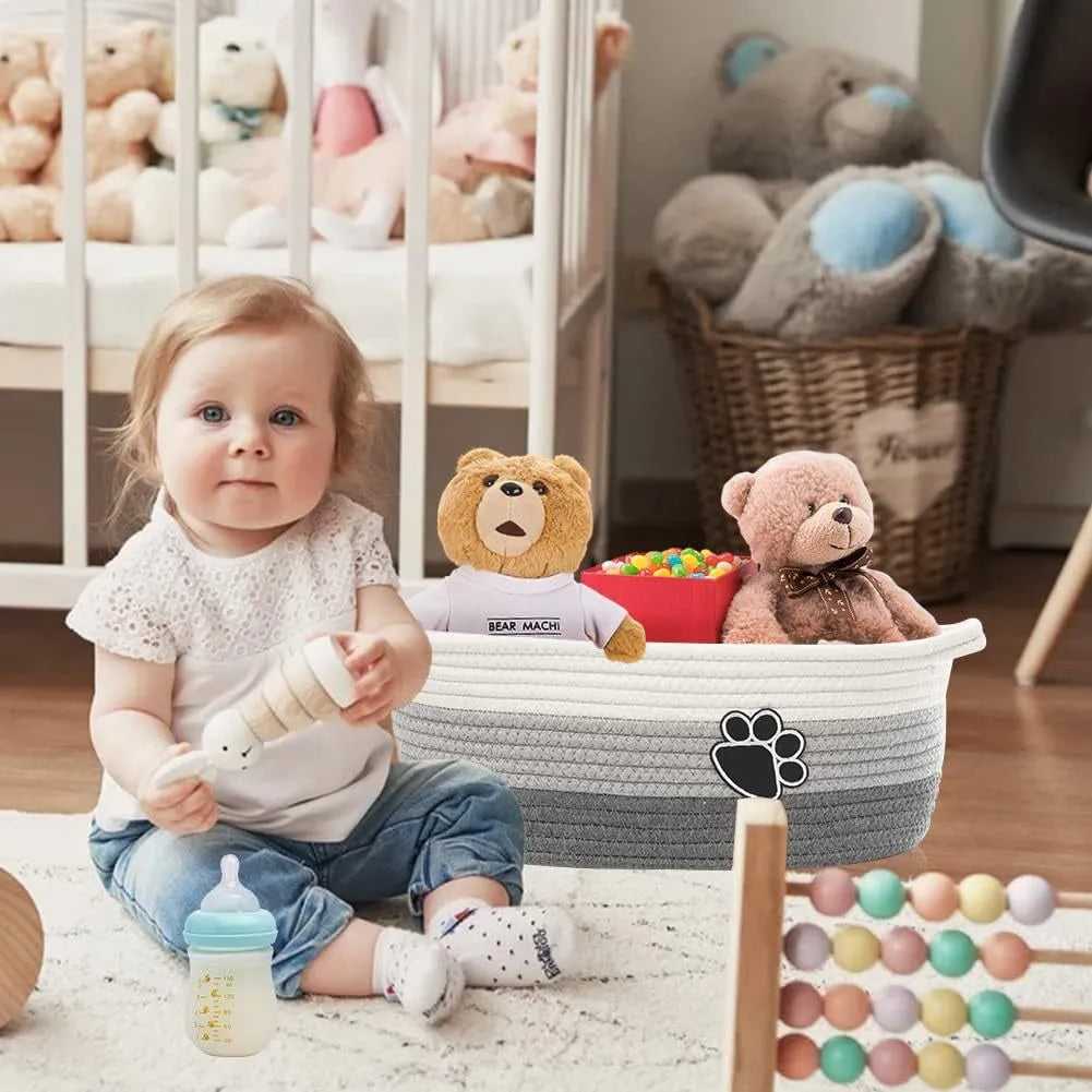Light beige handmade woven cotton rope storage basket with a handle on a wooden surface.