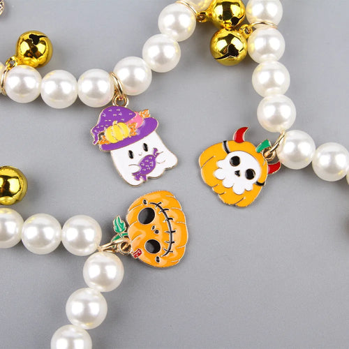 Purple simulated pearl cat collar with three Halloween pumpkin charms: ghost, skull, and smiley face.