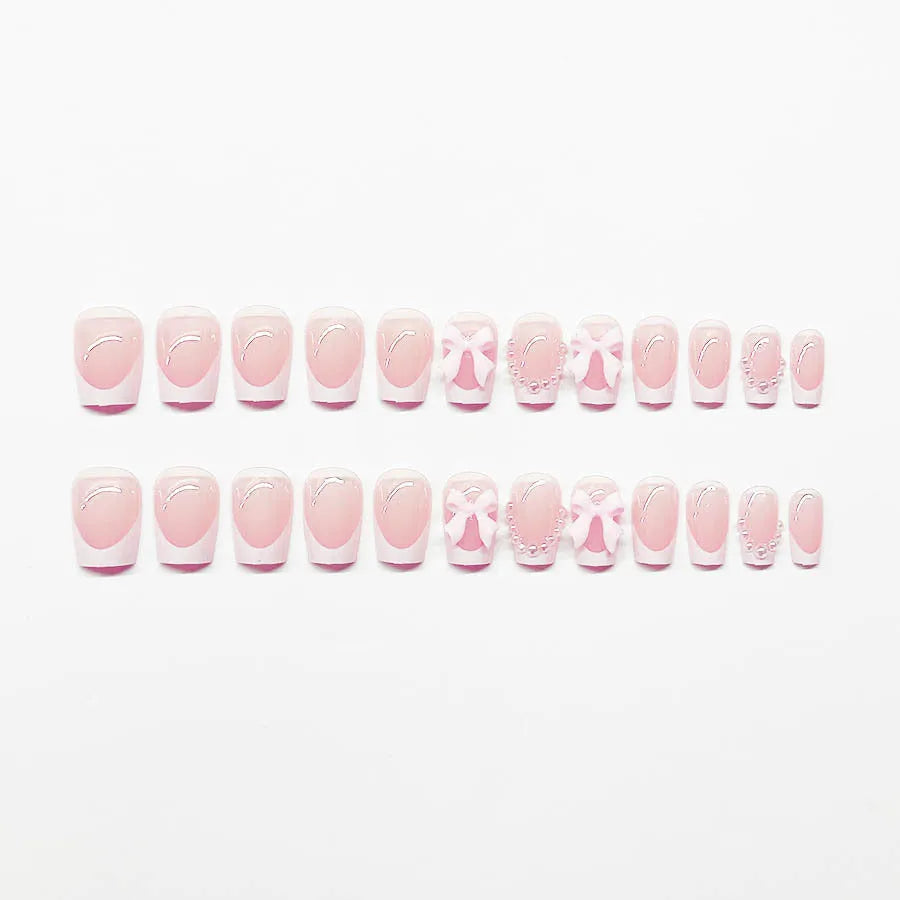 Set of short white French style press-on nail stickers with cute bow and tulip designs.