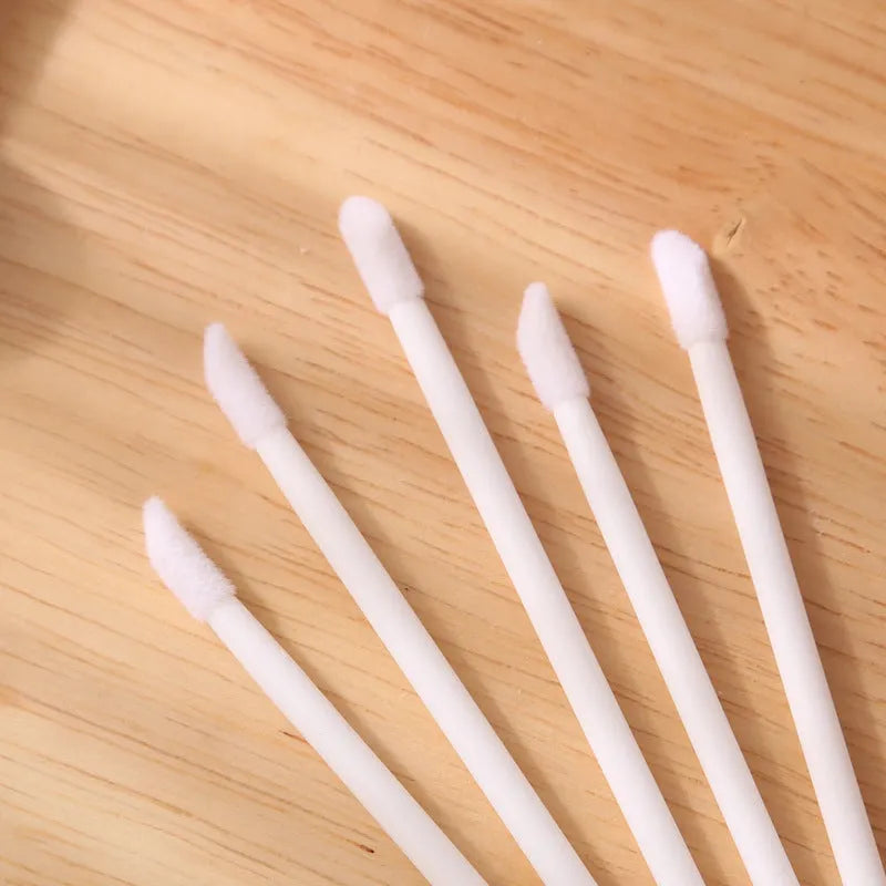 Disposable lip brush applicators with flocked heads in multiple handle colours on white background