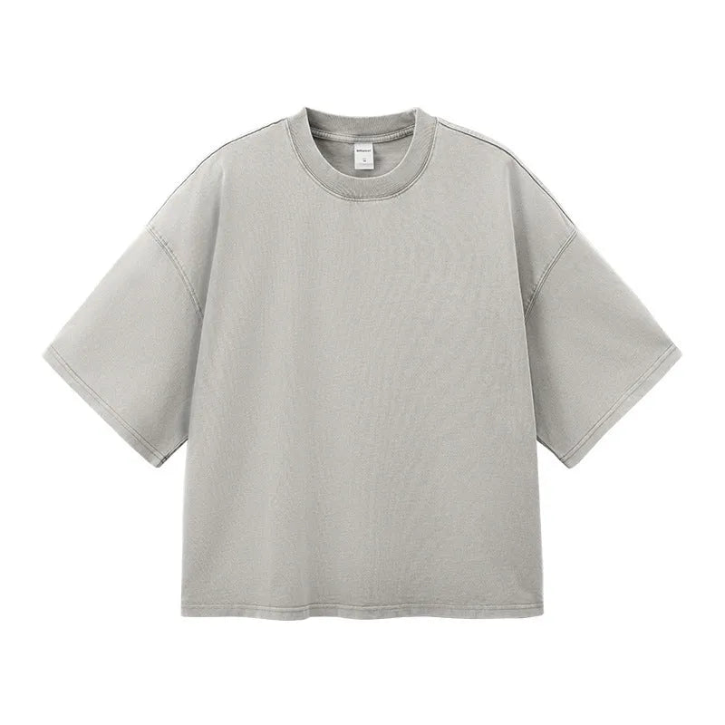 Man wearing a vintage washed khaki cotton t-shirt with loose fit and drop-shoulder sleeves.