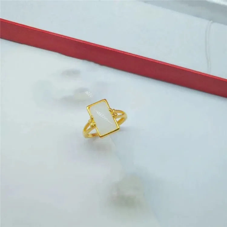Adjustable gold-plated brass ring with a long coloured gemstone in green, white, or black.