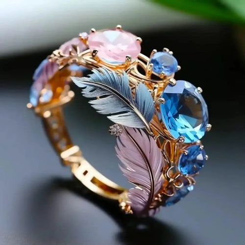 Gold-coloured brass feather ring with geometric embossed design and inlaid zircon stones