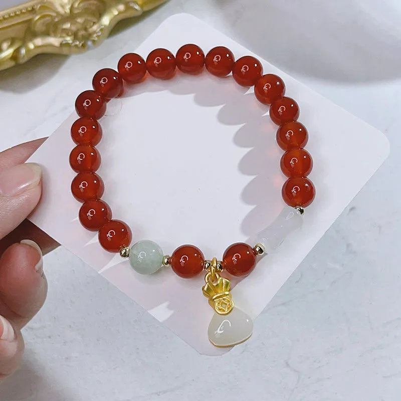 A red agate bracelet for women with Chinese style dragon and lucky bag motifs.