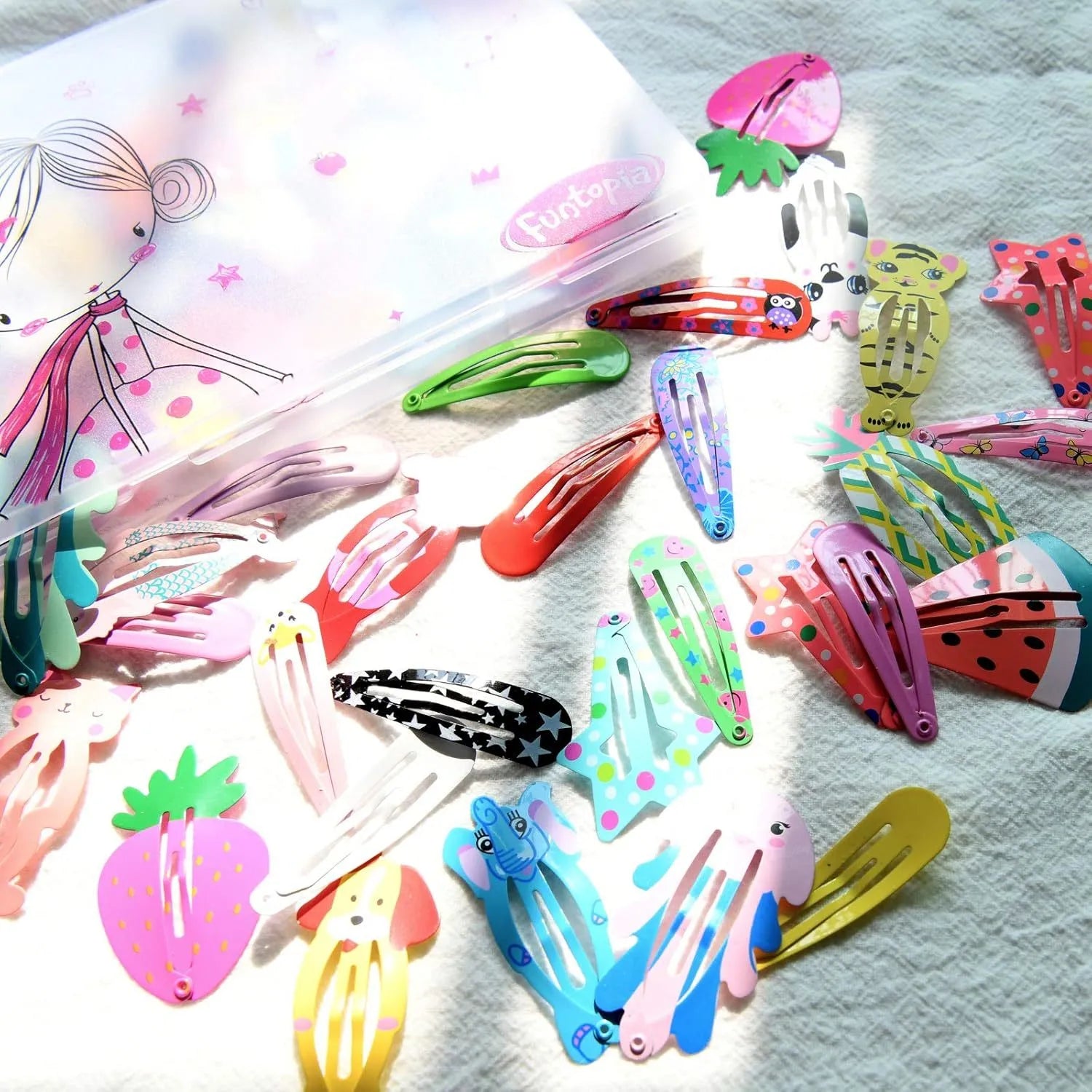 Assorted metal snap hair clips in bright colours showing animal, fruit, crown and star designs