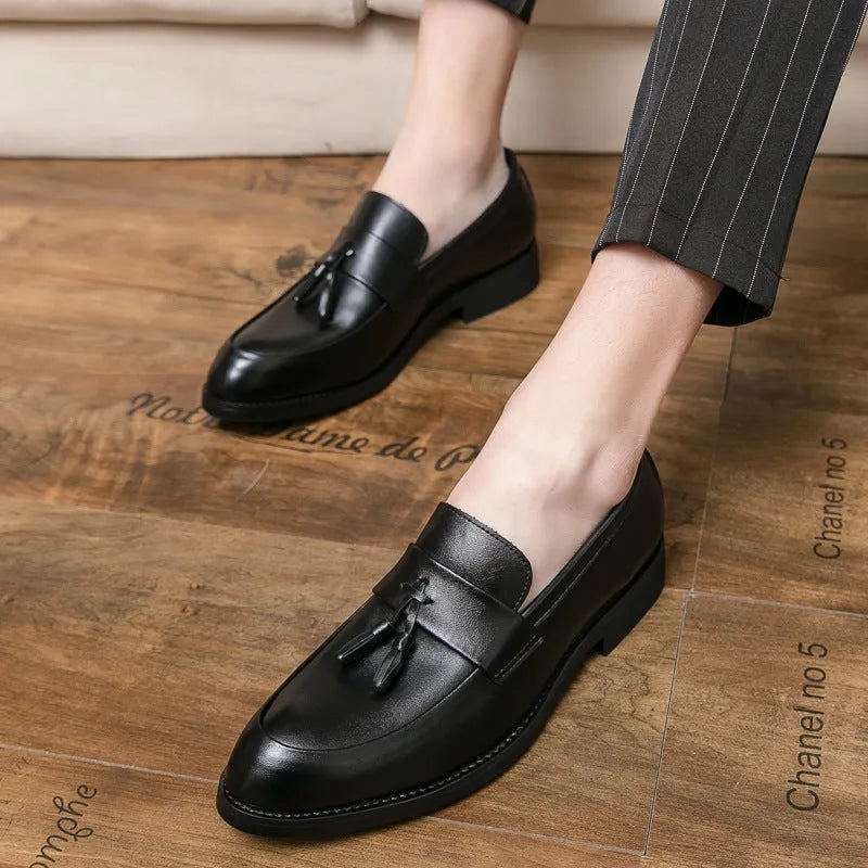 Men's black slip-on business casual shoes with a tassel detail on the artificial PU upper